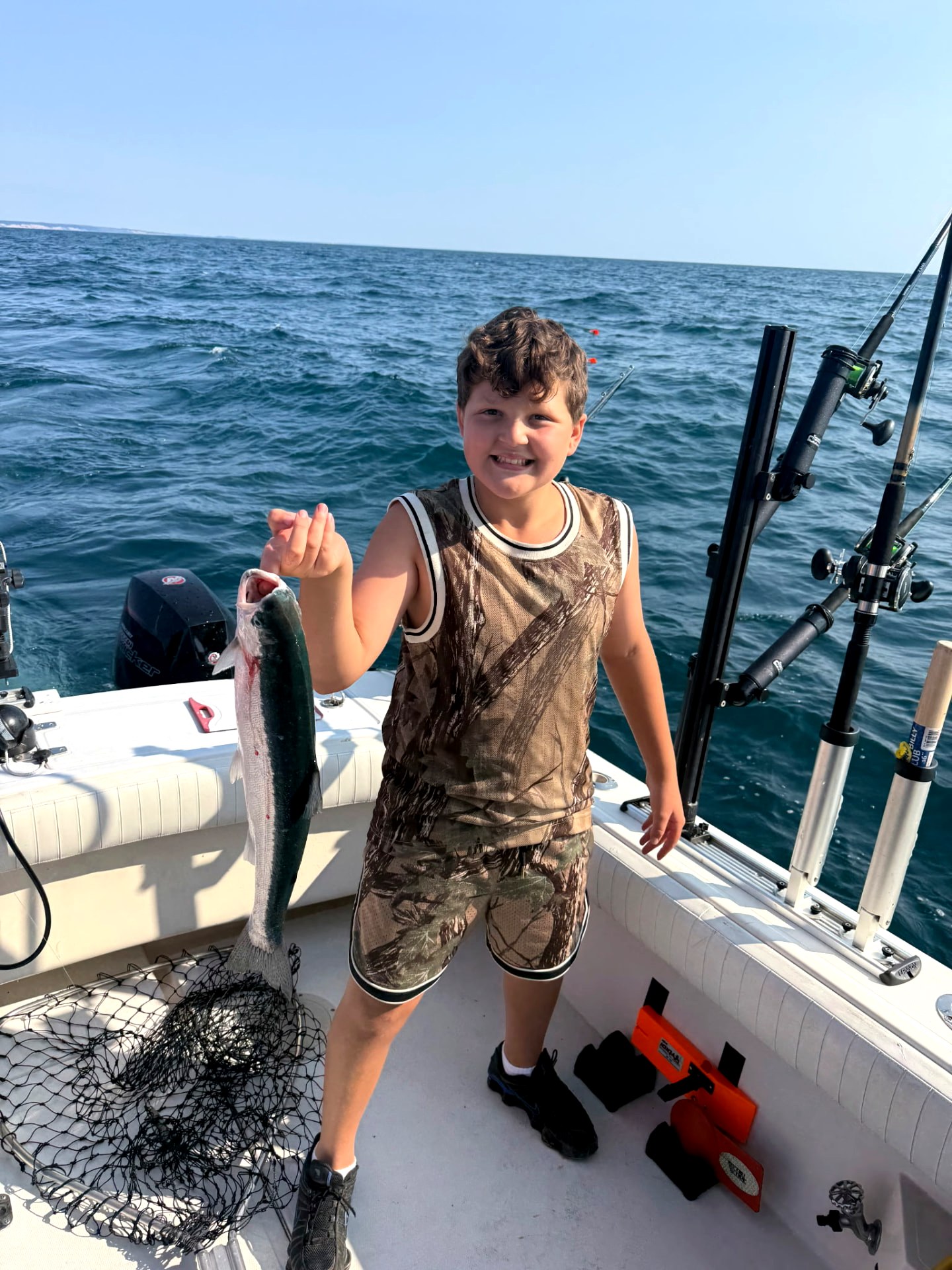 Young angler smiling with a fresh Lake Michigan salmon