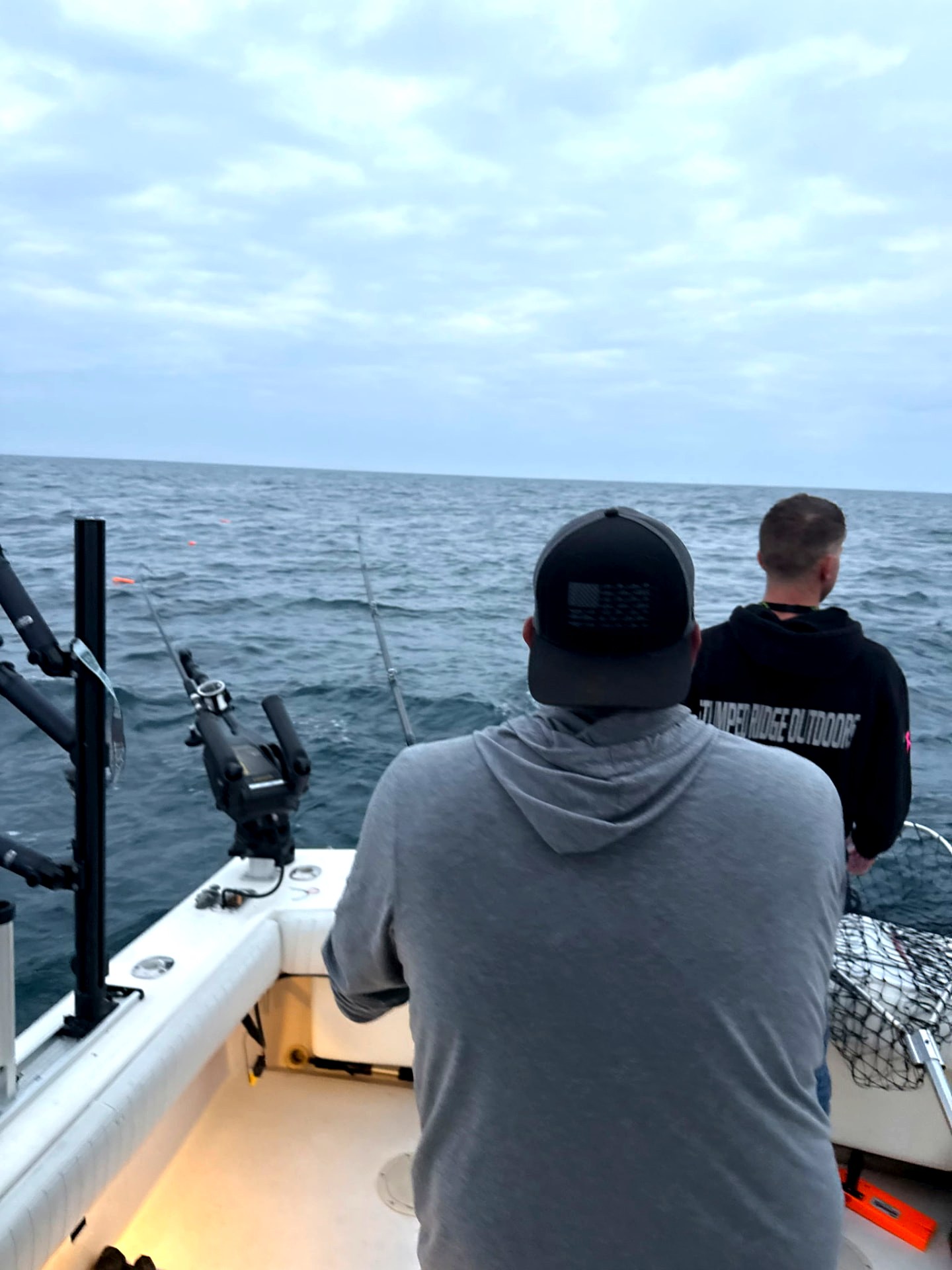 Crew watching the spread while trolling for salmon on Lake Michigan at sunrise
