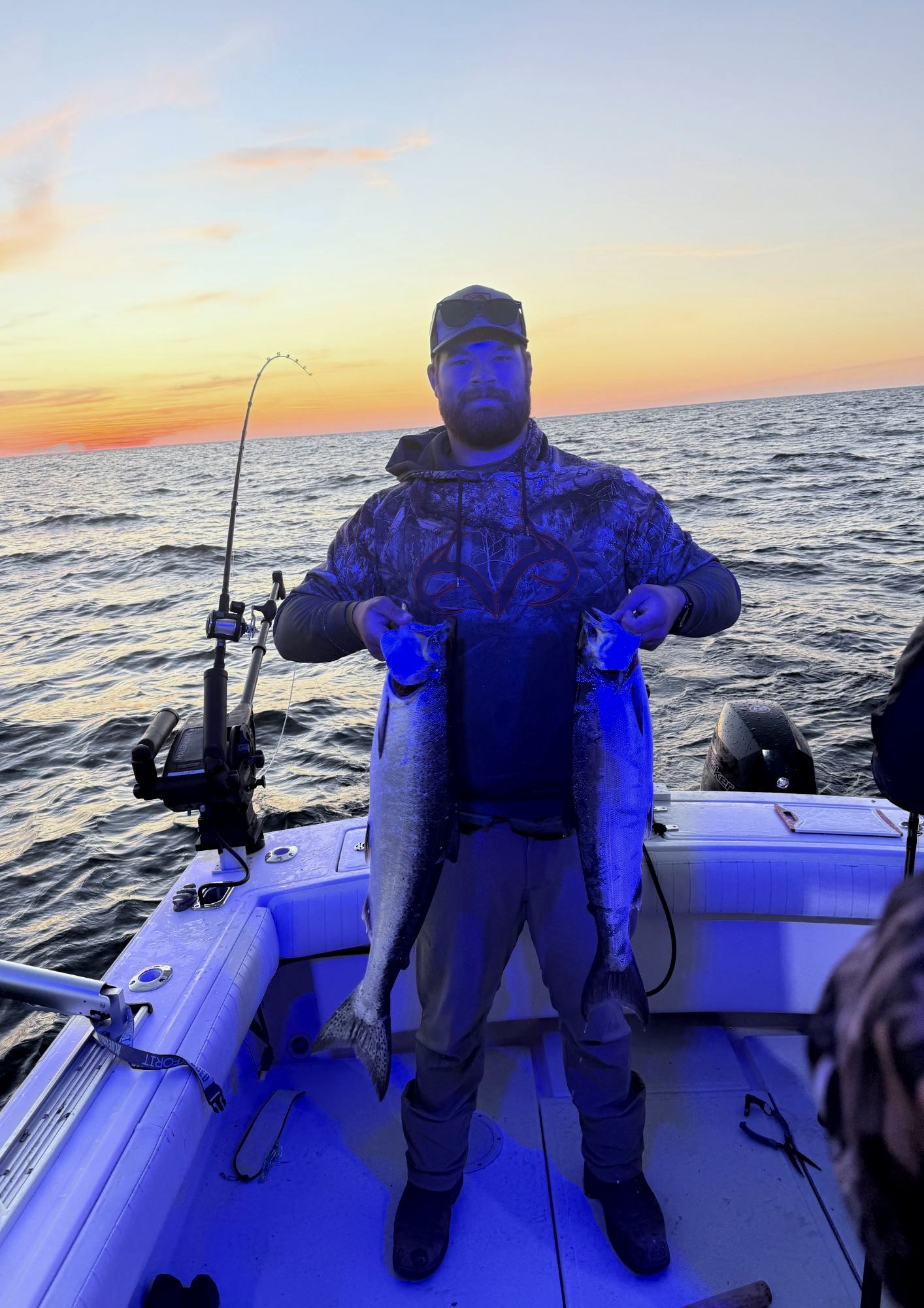 Captain Justin with a double salmon catch at sunset on Lake Michigan