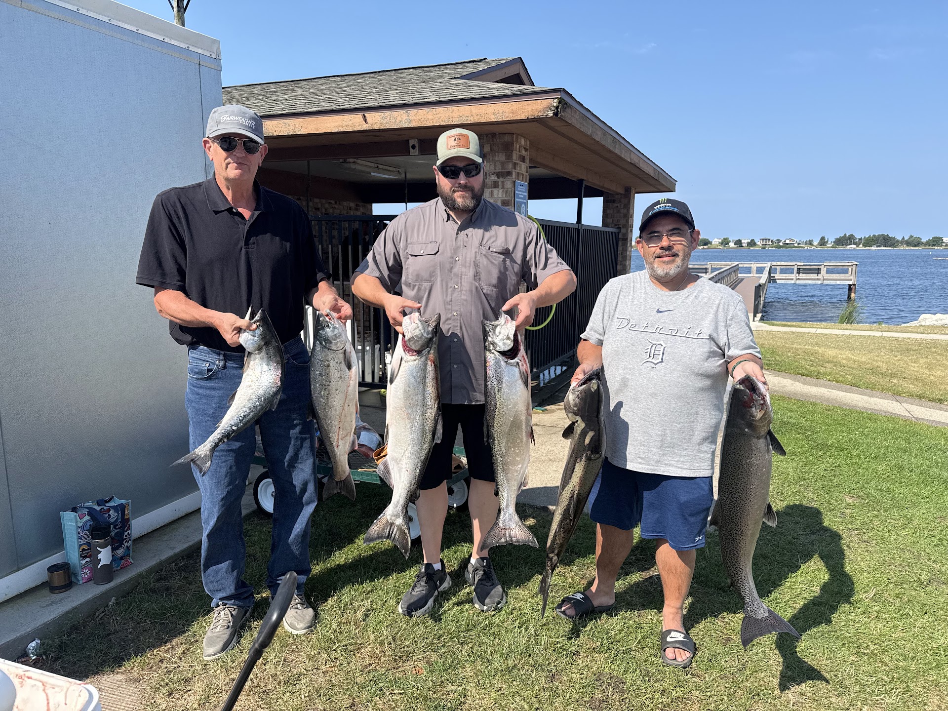 Three guests displaying their catch of salmon at the Ludington dock