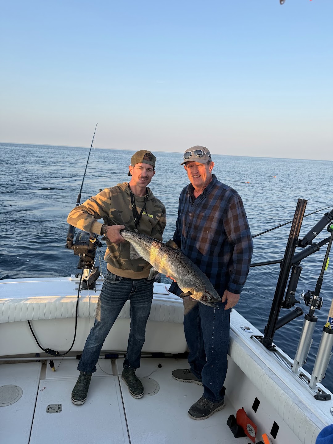Captain and guest holding a king salmon together on the charter boat